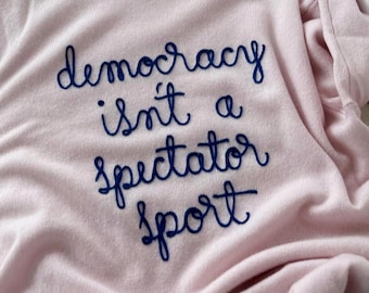 Cashmere Democracy Isn't a Spectator Sport, Chainstitch Embroidery Light Pink Crewneck Sweater, Cursive Style Font, Women's Shirt Size Small