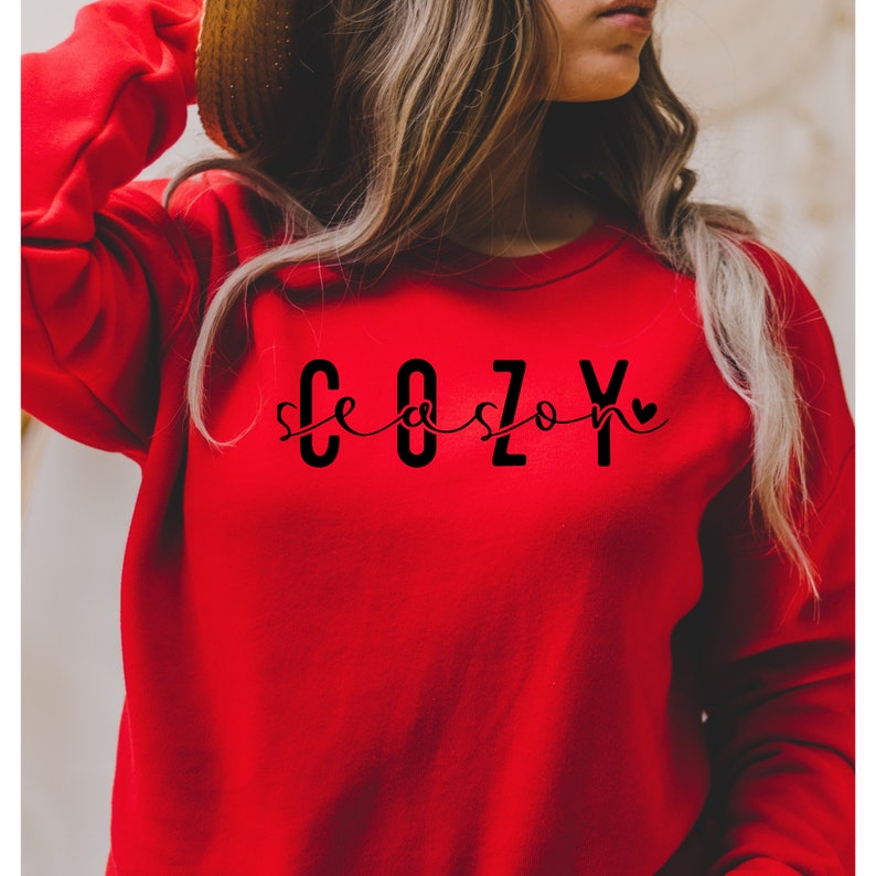 Puede incluir: Sudadera roja con el texto "Cozy season" en letras negras con un peque&ntilde;o coraz&oacute;n.
