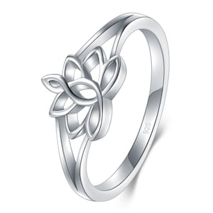 May include: A silver ring with a floral design. The ring features a stylized flower with multiple petals at the center. The band is smooth and polished, and the ring is made of a shiny, reflective metal. The ring is marked with "925".