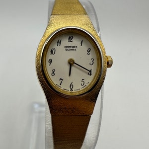 Reloj vintage Seiko 2Y00 para mujer, con esfera ovalada en tono dorado, ideal como regalo para mamá, en oferta, estilo japonés, con un pequeño detalle minimalista y circular.