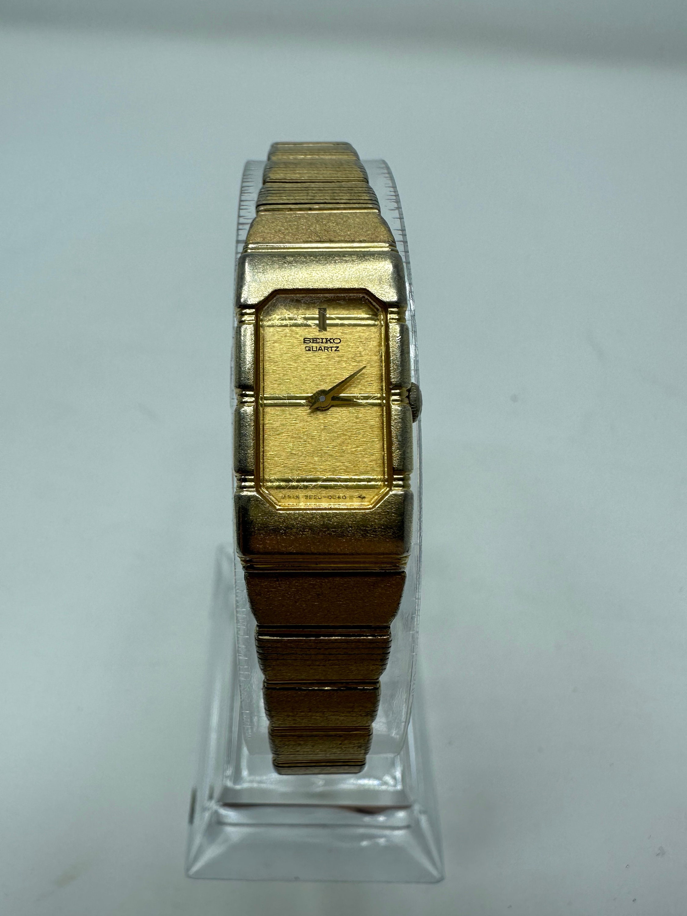 Montre Seiko vintage dorée avec cadran rectangulaire élégant 2E20