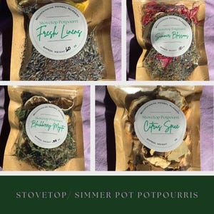 May include: Four brown paper bags with clear plastic windows, each containing a different type of stovetop potpourri. The bags are labeled with the name of the potpourri, "Stovetop Potpourri", and the approximate weight. The potpourris are: "Fresh Linens", "Summer Blossoms", "Blackberry Myst", and "Citrus Spice".