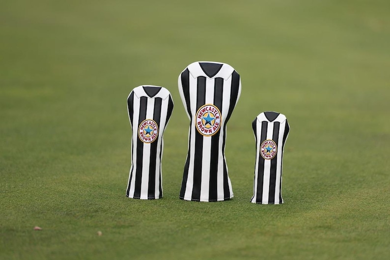 Peut inclure: Trois couvre-clubs de golf avec un motif &agrave; rayures noires et blanches, rappelant un maillot de football. Chaque couvre-club porte un &eacute;cusson circulaire avec une &eacute;toile bleue et l'inscription "Newcastle Brown Ale".