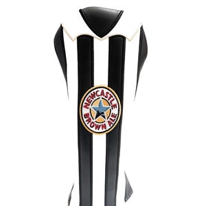 Peut inclure: Housse de club de golf &agrave; rayures noires et blanches, rappelant un maillot. Elle arbore un &eacute;cusson circulaire avec l'inscription "Newcastle Brown Ale" et une &eacute;toile. Fabriqu&eacute;e dans un mat&eacute;riau r&eacute;sistant.