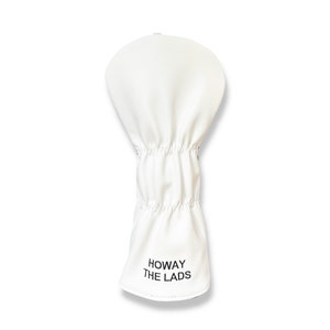 May include: A white golf club head cover with the text "HOWAY THE LADS" printed in black. The cover is made of a smooth material and has a gathered elastic section.
