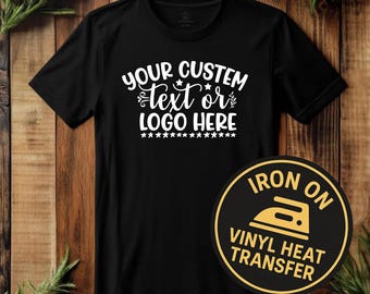 May include: Black t-shirt with white text that reads "YOUR CUSTOM TEXT OR LOGO HERE" and a star design. A circular iron-on vinyl heat transfer label is on the shirt.