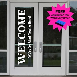 May include: White double doors with the word "WELCOME" in large, vertical, white letters. Below, the text reads "We're So Glad You're Here!" A pink starburst graphic displays "FREE Application Tool With Every Order!"