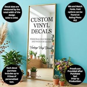 May include: A gold-framed mirror with the text "CUSTOM VINYL DECALS" and "PERSONALIZED MIRROR AND WINDOW SIGNS". The image includes text about decal sizes, font options, and personalized text lines. Plants and flowers are in the foreground.