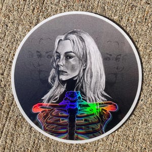 Klistermärke inspirerat av indie-alternativ kvinnlig sångerska 7,5 cm x 7,5 cm – holografisk skelettdesign