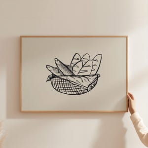 Könnte beinhalten: Eine Schwarzweiß-Zeichnung eines Korbes, gefüllt mit Brot und Fisch. Der Korb ist geflochten und hat einen Griff. Das Brot ist in Form von Laiben und die Fische sind stilisiert.