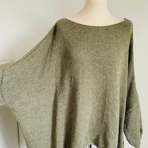 Könnte beinhalten: Ein locker sitzender, übergroßer grüner Strickpullover mit einem weiten Ausschnitt.