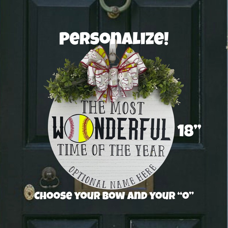 Puede incluir: Un colgador de puerta redondo de madera blanca de 45,7 cm con el texto "The Most Wonderful Time of the Year" y un gr&aacute;fico de softbol. El colgador de puerta est&aacute; decorado con un lazo rojo y blanco con un patr&oacute;n de softbol. El texto "&iexcl;Personalizar!" est&aacute; en la parte superior de la imagen y el texto "Elige tu lazo y tu "O"" est&aacute; en la parte inferior de la imagen.