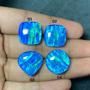 May include: Four vibrant blue opal gemstones in various shapes: two square, one triangular, and one round. Each stone displays a mesmerizing play of color with streaks of green and blue, numbered 01 through 04.