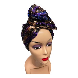 May include: A sequined head wrap in shades of purple, gold, and black. The wrap is tied in a knot on top of the head and falls down the sides.