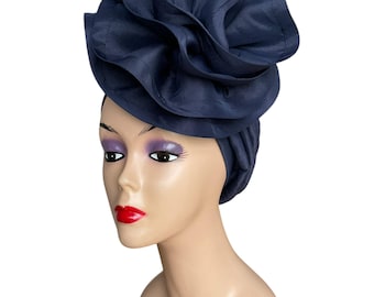 May include: A navy blue fabric head wrap with a large, ruffled flower design.