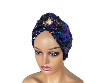 May include: A black, blue, and purple sequined turban headband. The turban is made of a soft, stretchy fabric and is perfect for adding a touch of glamour to any outfit.
