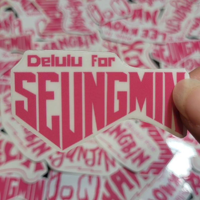 May include: Pink and white sticker with the text "Delulu For SEUNGMIN" in a bold, stylized font.