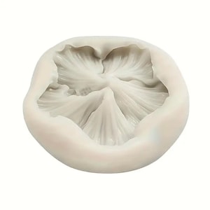 Puede incluir: Un molde de silicona blanco con forma de flor de cinco pétalos. El molde está diseñado para hacer flores de azúcar decorativas para pasteles y otros postres.