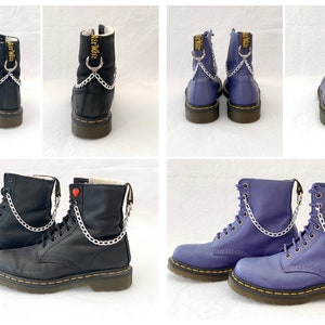 May include: Black and purple leather combat boots with silver chain accents. The boots have a lace-up design and a yellow stitched sole. The purple boots have a silver chain and the black boots have a silver chain and a red heart charm.