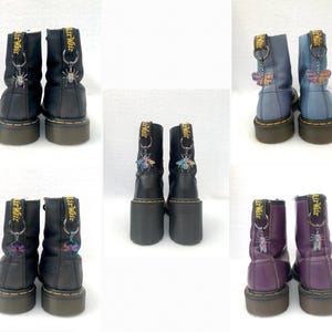 May include: Three pairs of black leather boots with yellow and black