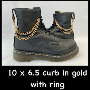 以下が含まれることがあります： 黒い革のブーツに金のチェーンのアクセントが施されています。チェーンの長さは25.4cm、幅は6.5mmです。チェーンはカーブリンクスタイルで、端にリングが付いています。