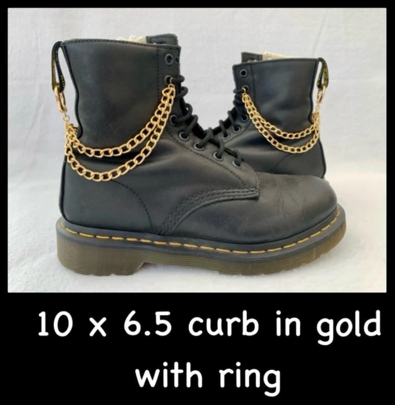 以下が含まれることがあります： 黒い革のブーツに金のチェーンのアクセントが施されています。チェーンの長さは25.4cm、幅は6.5mmです。チェーンはカーブリンクスタイルで、端にリングが付いています。