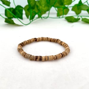 May include: A brown wooden beaded bracelet with a simple design.