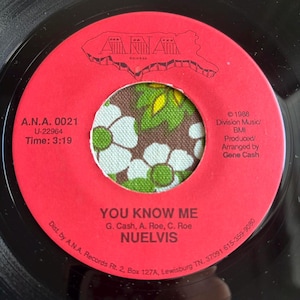 May include: A vintage vinyl record with a red label featuring the text "YOU KNOW ME" by NUELVIS. The center of the record has a floral pattern. The label also includes the A.N.A. Records logo and copyright information.