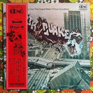 May include: Album cover for the "Earthquake" soundtrack. The cover features the title "Earthquake" in a distressed, 3D font, with a cityscape crumbling beneath it. A red banner with Japanese text and the CD-4 logo is on the left. The album is from MCA Records.