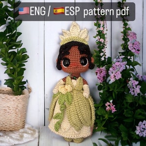 Könnte beinhalten: Gehäkelte Prinzessinnenpuppe in einem grünen und cremefarbenen Kleid, mit Krone und Halskette. Die Puppe hat große, dunkle Augen und schwarzes Haar. Der Text "ENG / ESP pattern pdf" ist im Bild enthalten.