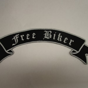 Könnte beinhalten: Schwarzer und weißer gestickter Aufnäher mit dem Text "Free Biker" auf einem gebogenen Banner.
