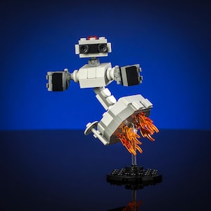 May include: A white and gray LEGO robot with red and black accents is flying with orange flames coming from its feet. The robot is on a black base.