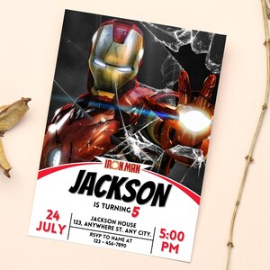 May include: An Iron Man birthday party invitation. The design features Iron Man with a cracked glass effect. The invitation includes the name "Jackson", age "5", date "24 July", time "5:00 PM", and RSVP details.
