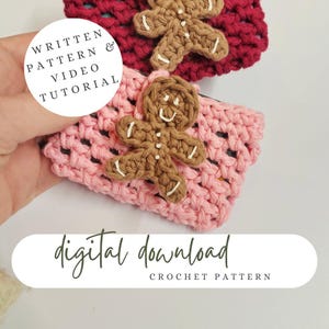 May include: Two crocheted coffee cup cozies with gingerbread man appliques. The cozies are pink and red. The text "WRITTEN PATTERN & VIDEO TUTORIAL" is on a white circle. The text "digital download CROCHET PATTERN" is on a white rectangle.