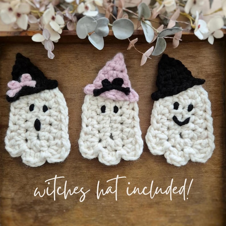 May include: Three handmade crochet ghosts with black and pink witch hats. Each ghost has a unique facial expression, with button eyes and a stitched mouth. The text "witches hat included!" is written in a cursive font.