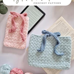 May include: Two crocheted ebook covers, one in pale pink and the other in pale blue, each with a matching ribbon tie. The text "digital download CROCHET PATTERN" is at the top. Several skeins of yarn in similar colours are below.