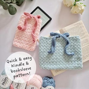 May include: Two handmade crochet Kindle and booksleeves in pink and blue, each with a decorative bow. The pink sleeve holds a Kindle. The text on the image says "Quick & easy Kindle & booksleeve pattern!" Several balls of yarn are at the bottom.