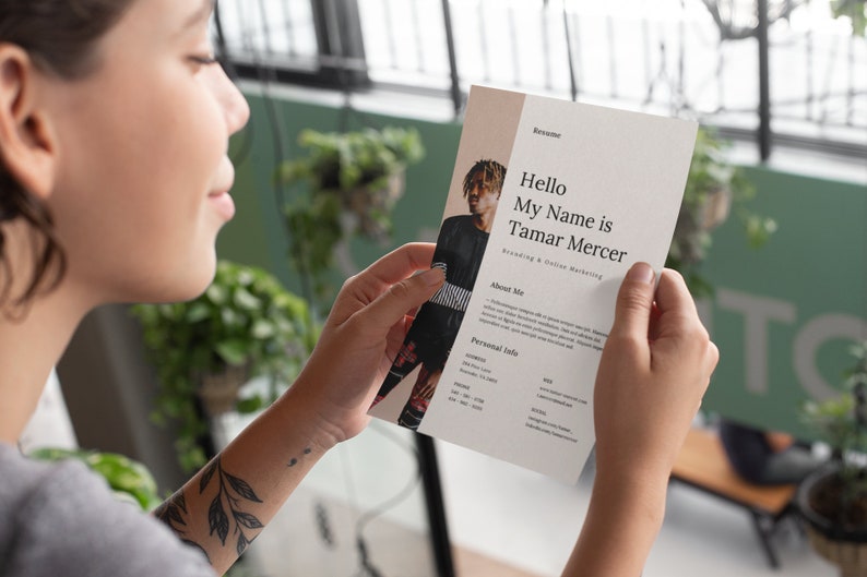 May include: A resume with a photo of a person with dreadlocks wearing a black and white striped shirt. The resume is titled "Hello My Name is Tamar Mercer" and lists "Branding & Online Marketing" as their specialty. The resume also includes a section titled "About Me" and "Personal Info".