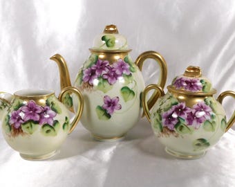Unmarkierte Teekanne, Zuckerdose und Milchkännchen mit violetten Blumen # 24026