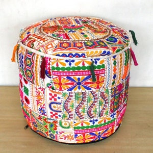 Pode incluir: Um pufe redondo, branco, multicolorido, bordado, de patchwork com borlas.