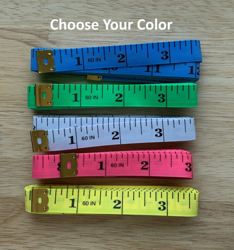 Pode incluir: Cinco fitas m&eacute;tricas de diferentes cores: azul, verde, branco, rosa e amarelo. Cada fita &eacute; marcada em polegadas e tem uma tampa de metal.