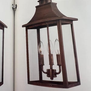May include: A bronze-colored, rectangular pendant light fixture with clear glass panels. The fixture has a decorative top and holds three light bulbs. The model number "8316CP" is printed on the bottom.