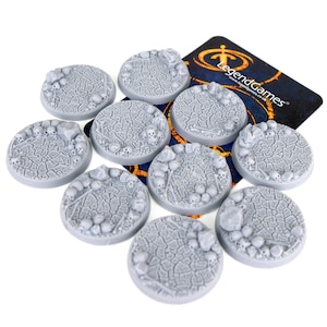 Peut inclure: Dix socles en plastique gris pour figurines miniatures avec un motif de terre craquelée et de crânes. Les socles ont un diamètre de 25 mm. Les socles sont destinés à être utilisés dans les jeux de table et les jeux de rôle.