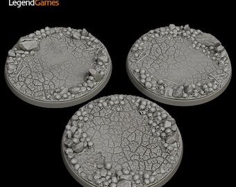 May include: Three gray plastic miniature gaming bases with a cracked earth and skull design. The bases are round and have a raised edge.