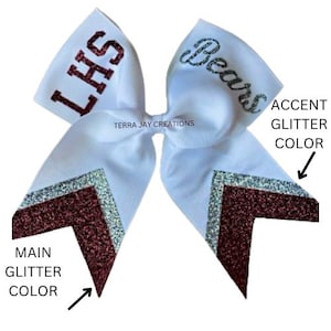 May include: White cheer bow with the text "LHS" and "Bears" in maroon glitter. The bow has two silver glitter accents on each side.