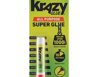 Op de afbeelding: Een geel en groene verpakking met een witte tube Krazy Glue All Purpose Super Glue. De tube heeft een rode dop en een label met de tekst "Krazy Glue All Purpose Super Glue". De verpakking heeft de tekst "Holds Over 1000 lbs. Krazy Strong" en "10 Seconds Krazy Fast".
