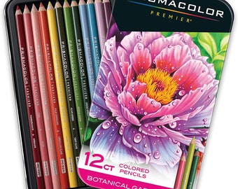 Könnte beinhalten: Ein Set mit 12 Prismacolor Premier Farbstiften in einer Blechdose. Die Stifte sind in einer Reihe angeordnet und mit ihren Farbnamen beschriftet. Die Dose hat ein florales Design mit einer rosa Blume und grünen Blättern. Der Text auf der Dose lautet "12ct Farbstifte Botanischer Garten Set".