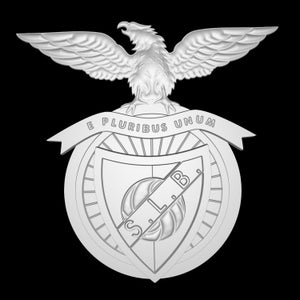 Może przedstawiać: Biały, trójwymiarowy emblemat z  stylizowanym orłem osadzonym na kuli ziemskiej. Kula ziemska ma tarczę z literami "S.L.B." wewnątrz. Tekst "E PLURIBUS UNUM" jest napisany na wstędze wokół kuli ziemskiej.