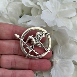 Hunger Games metal mockingjay/ mockingbird & arrow pin badge brooch presented in an organza gift bag Silver