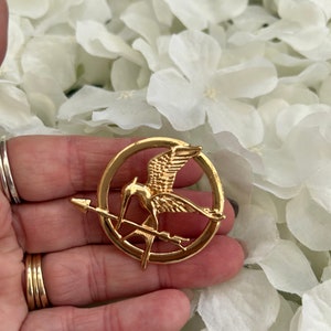 Hunger Games metal mockingjay/ mockingbird & arrow pin badge brooch presented in an organza gift bag Copper